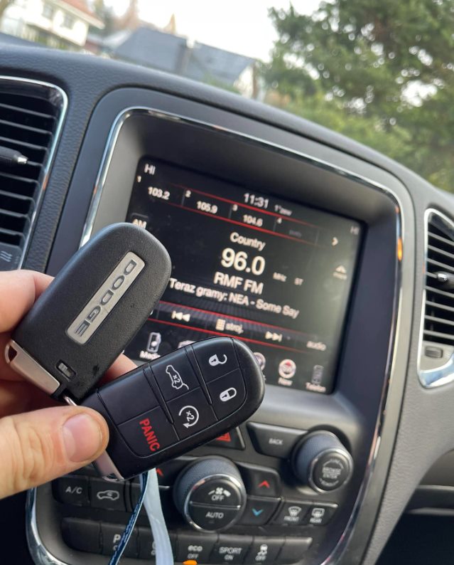 Dwa kluczyki Dodge na tle radia Uconnect